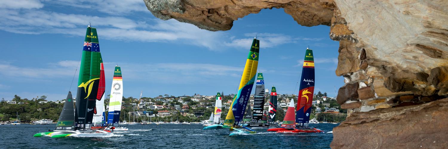 The fleet led by Australia SailGP Team helmed by Tom Slingsby with Canada NorthStar SailGP Team, Germany SailGP Team, Mubadala Brazil SailGP Team and Spain SailGP Team as seen from Shark Island on Race Day 1 of the KPMG Australia Sail Grand Prix in Sydney, Australia. Saturday 8 February 2025