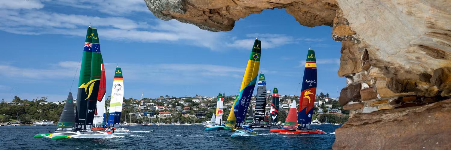 The fleet led by Australia SailGP Team helmed by Tom Slingsby with Canada NorthStar SailGP Team, Germany SailGP Team, Mubadala Brazil SailGP Team and Spain SailGP Team as seen from Shark Island on Race Day 1 of the KPMG Australia Sail Grand Prix in Sydney, Australia. Saturday 8 February 2025