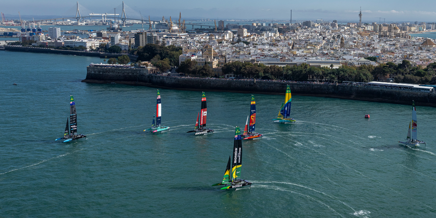 Emirates Great Britain SailGP Team helmed by Dylan Fletcher leads New Zealand SailGP Team helmed by Peter Burling, USA SailGP Team helmed by Taylor Canfield, ROCKWOOL Denmark SailGP Team helmed by Nicolai Sehested, Spain SailGP Team helmed by Diego Botin and Mubadala Brazil SailGP Team helmed by Martine Grael past the SailGP Race Stadium on Race Day 2 of the DP World Spain Sail Grand Prix held in Cadiz, Spain Sunday 5 October 2025